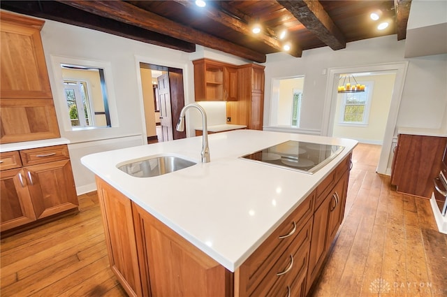 kitchen featuring plenty of natural light, a kitchen island with sink, wooden ceiling, and beam ceiling