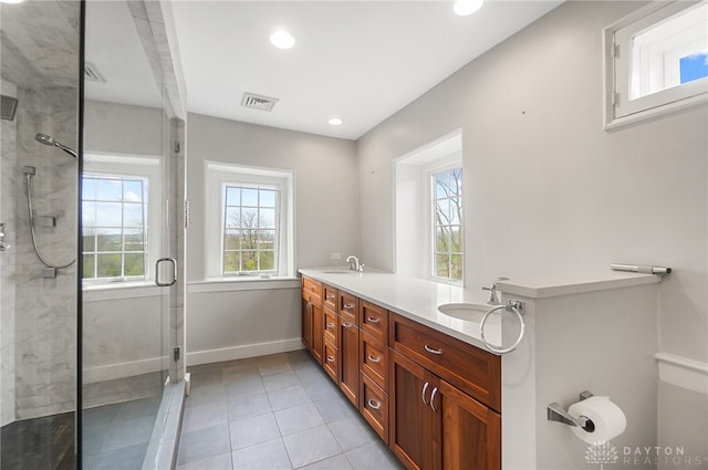 bathroom featuring tile patterned flooring, dual vanity, and a shower with shower door