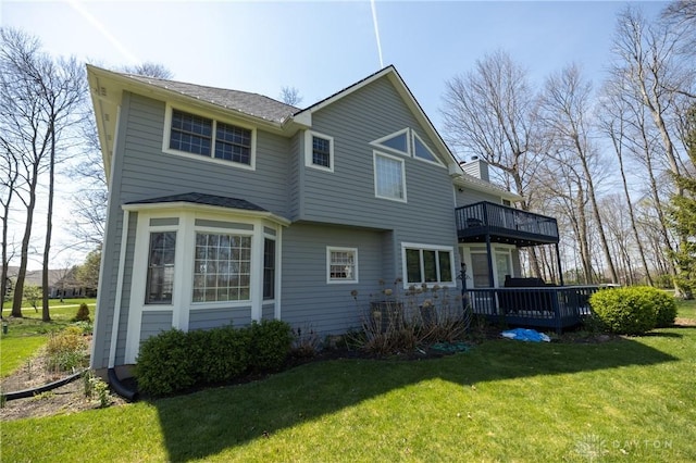 rear view of property with a lawn and a deck