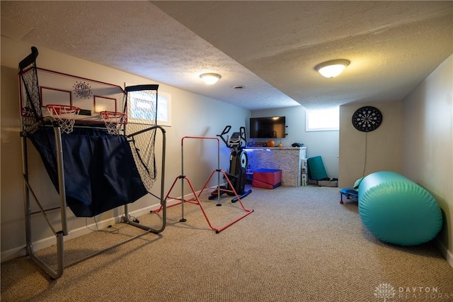 exercise area featuring a textured ceiling and carpet flooring