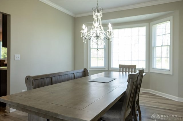 dining area featuring a notable chandelier, ornamental molding, and hardwood / wood-style floors