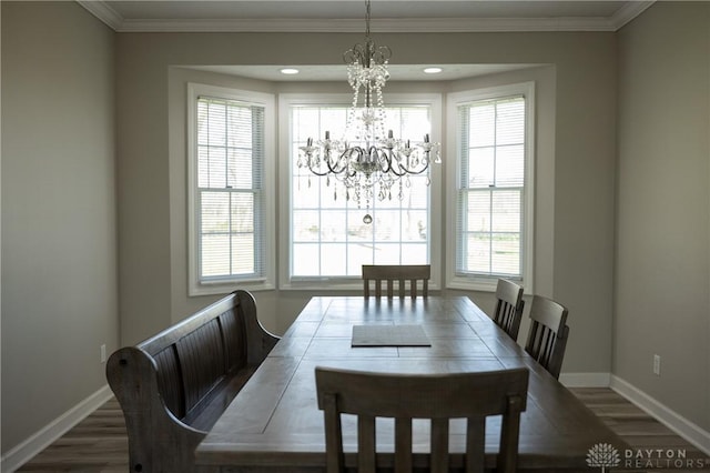 dining space featuring an inviting chandelier, ornamental molding, plenty of natural light, and dark wood-type flooring