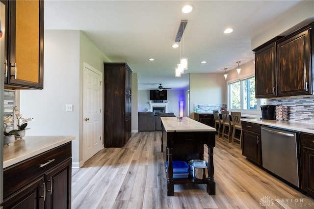 kitchen with dishwasher, pendant lighting, a center island, backsplash, and ceiling fan