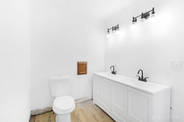 bathroom featuring toilet, vanity, and hardwood / wood-style flooring