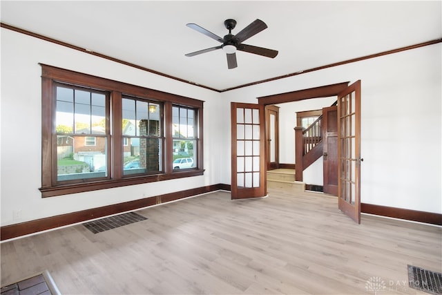 unfurnished room with light hardwood / wood-style flooring, ornamental molding, ceiling fan, and french doors