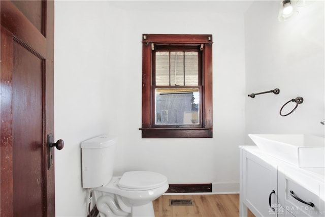 bathroom featuring vanity, wood-type flooring, and toilet