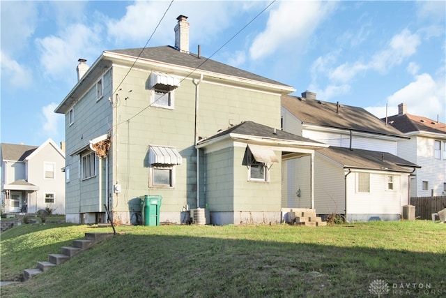 back of house featuring a lawn and cooling unit