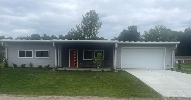 ranch-style house featuring a front yard, concrete driveway, and an attached garage