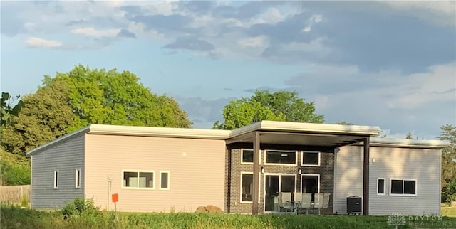 rear view of house with central AC and brick siding