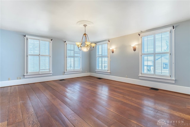 2696 Wilmington Rd, Lebanon, OH 45036 - unfurnished dining area featuring wood-type flooring, visible vents, baseboards, and a notable chandelier