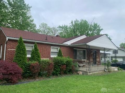 view of front of property featuring brick siding and a front lawn