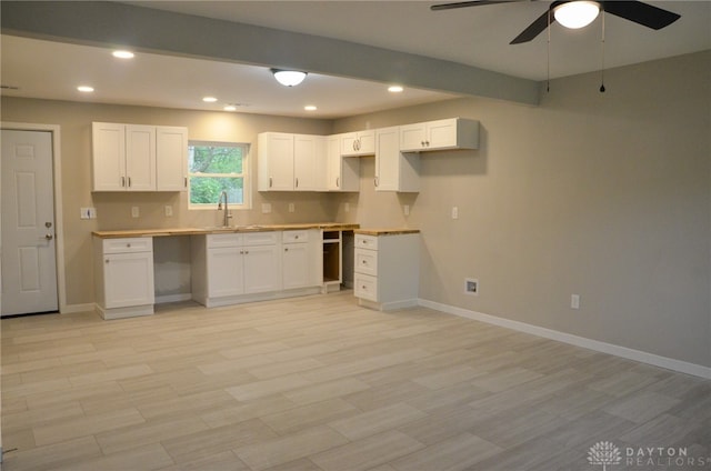 kitchen featuring sink, white cabinetry, light hardwood / wood-style floors, and ceiling fan