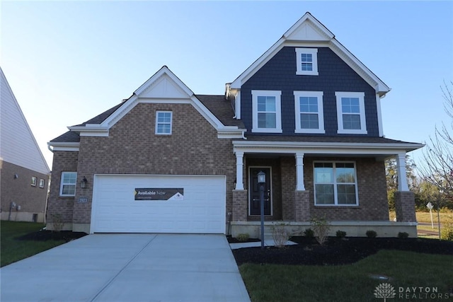 craftsman inspired home with a front yard, a porch, concrete driveway, and brick siding