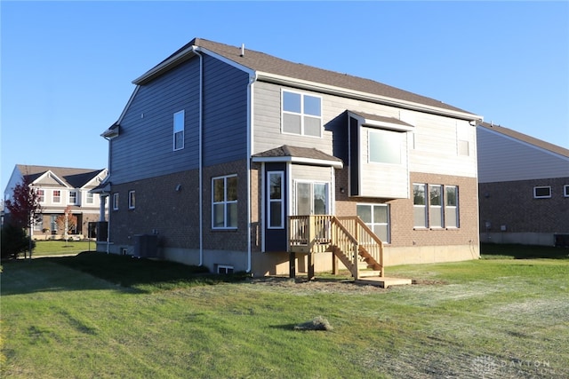 back of house featuring a yard and central AC unit