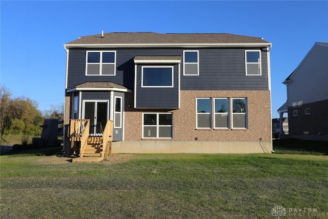 rear view of house featuring brick siding and a lawn