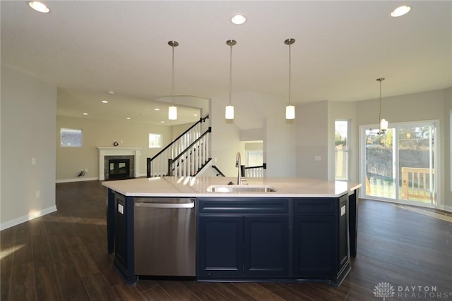 kitchen with a sink, open floor plan, light countertops, dishwasher, and an island with sink