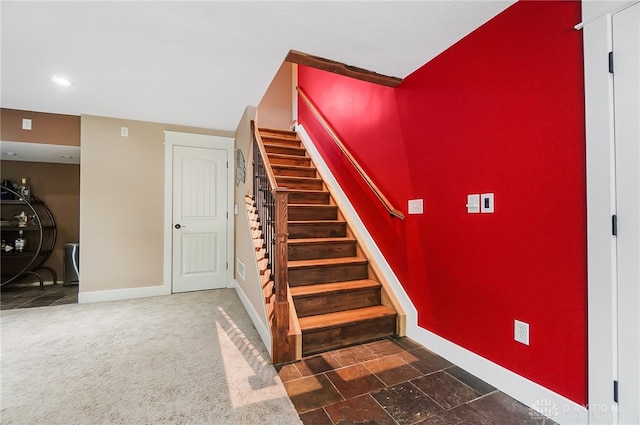 stairway featuring carpet