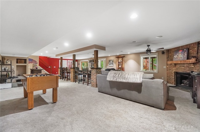 carpeted living room featuring a fireplace, a healthy amount of sunlight, and ceiling fan