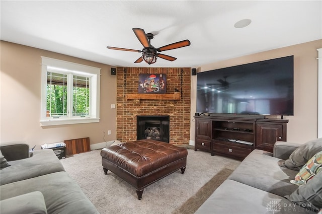 living room featuring a fireplace, ceiling fan, and light carpet