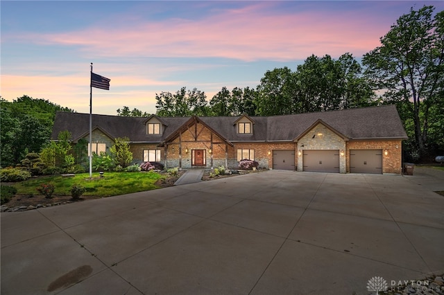 view of front of house featuring a garage and a lawn