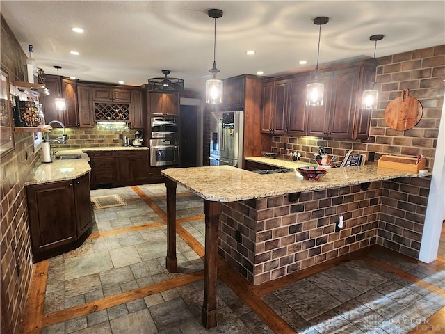 kitchen with pendant lighting, kitchen peninsula, and stainless steel appliances