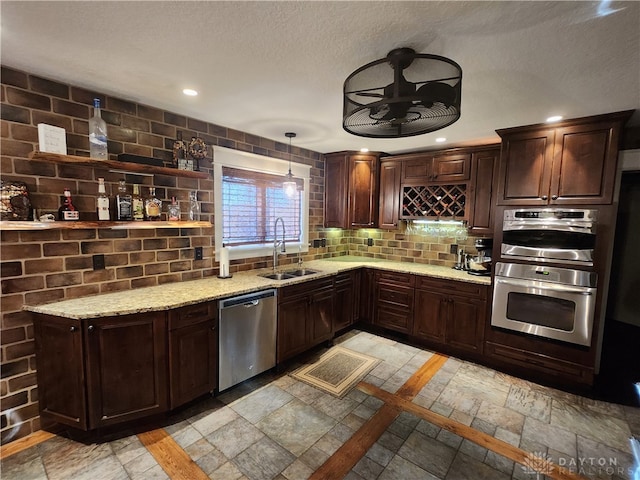 kitchen featuring pendant lighting, appliances with stainless steel finishes, sink, and dark brown cabinets