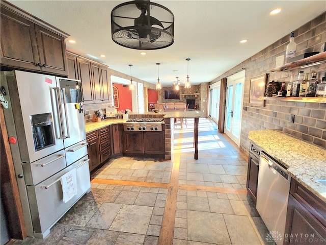 kitchen featuring a kitchen bar, kitchen peninsula, backsplash, appliances with stainless steel finishes, and decorative light fixtures