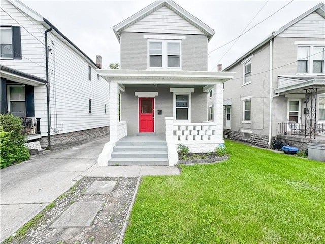 view of front of house with covered porch and a front yard