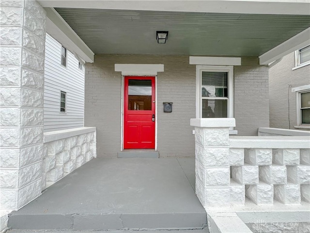 doorway to property featuring brick siding