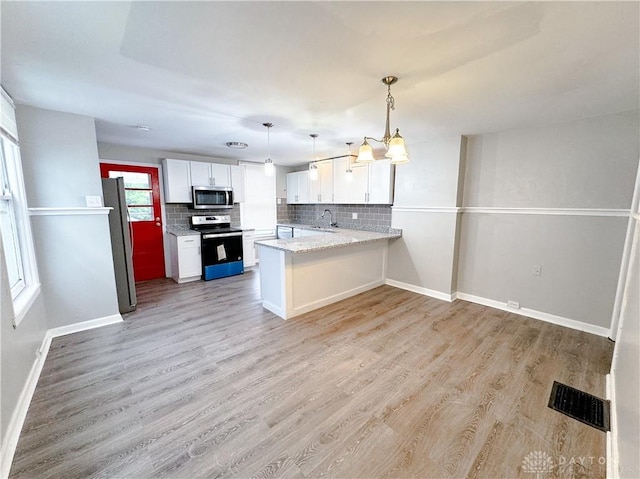 kitchen with a sink, white cabinetry, appliances with stainless steel finishes, and tasteful backsplash