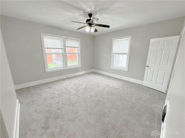 spare room featuring plenty of natural light, a ceiling fan, and carpet