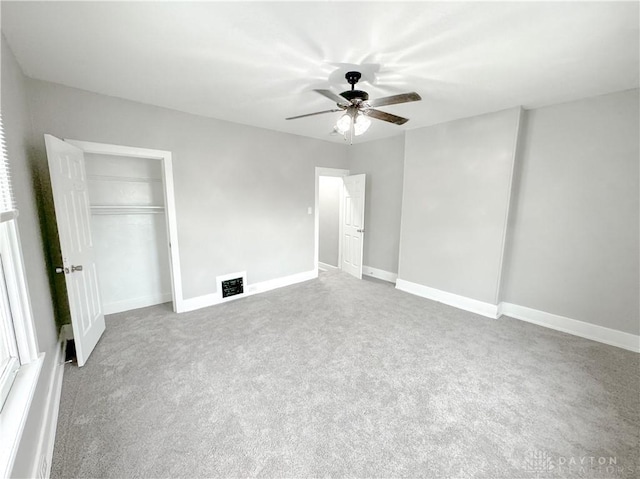 unfurnished bedroom with ceiling fan, visible vents, carpet floors, baseboards, and a closet
