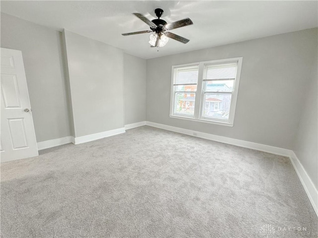 carpeted empty room with baseboards and ceiling fan