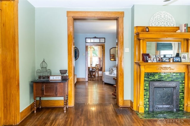 corridor featuring baseboards, visible vents, and wood finished floors