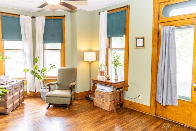 sitting room featuring ceiling fan, hardwood / wood-style floors, and baseboards