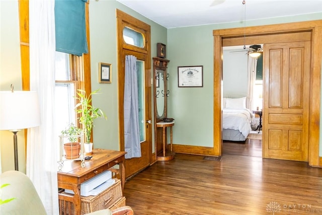 foyer entrance with ceiling fan, baseboards, and wood finished floors