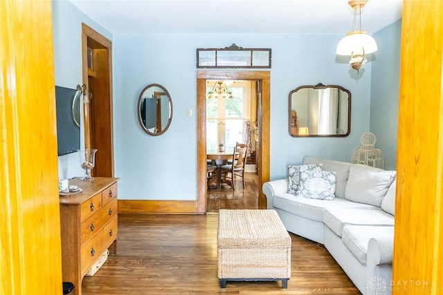 living area with baseboards and wood finished floors