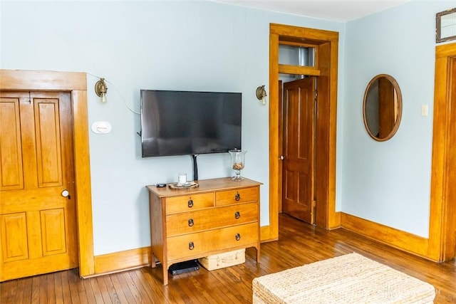 bedroom with hardwood / wood-style floors and baseboards