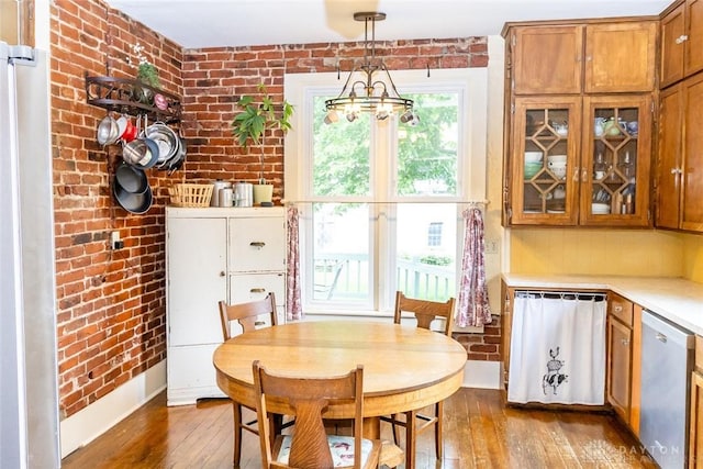 dining space featuring a chandelier, brick wall, and hardwood / wood-style flooring