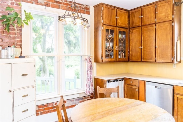 kitchen with brick wall, light countertops, brown cabinets, dishwasher, and glass insert cabinets