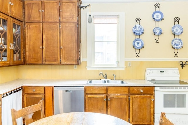 kitchen with dishwasher, glass insert cabinets, light countertops, white electric range, and a sink