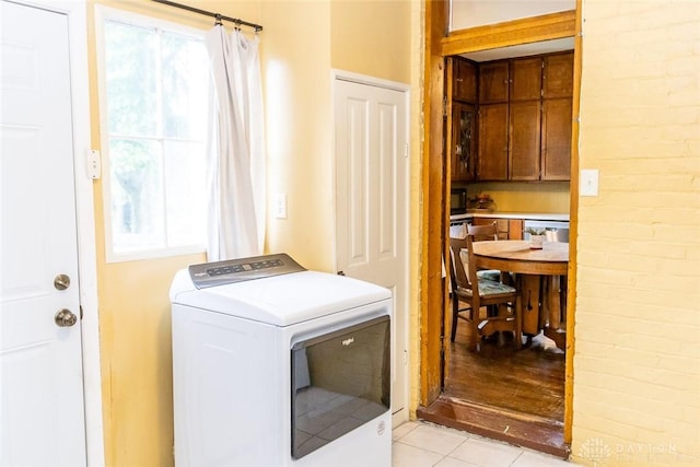 clothes washing area with laundry area, washer / clothes dryer, and light tile patterned floors