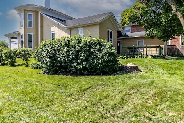 view of property exterior with brick siding and a lawn