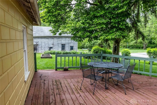 wooden deck with outdoor dining area and a yard