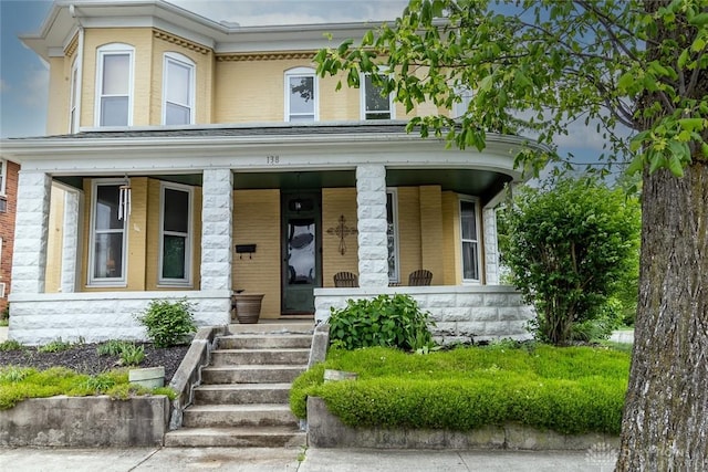 view of front of house featuring covered porch and brick siding