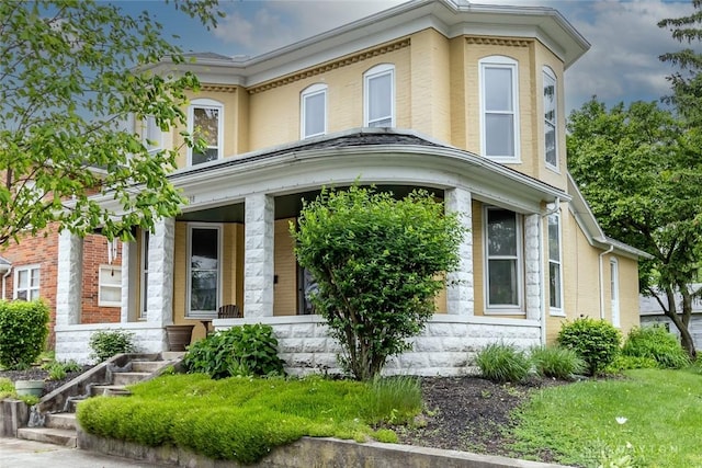 view of front of home featuring covered porch and brick siding