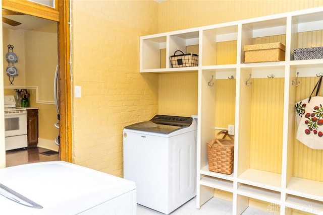 laundry room featuring washer and dryer, laundry area, and brick wall