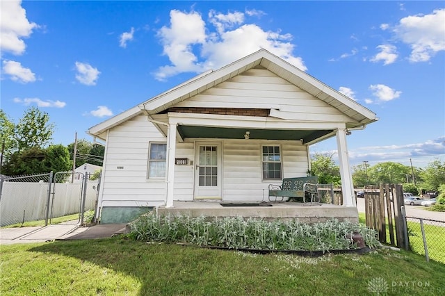 bungalow with a front lawn and covered porch