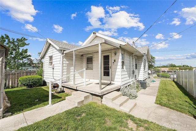 bungalow-style house featuring covered porch and a front yard