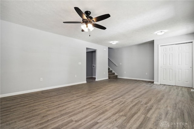 interior space featuring stairs, a textured ceiling, wood finished floors, and baseboards